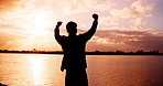 Ocean, silhouette and man with success, cheering and sunset with freedom, challenge and excited. Back, beach and person with achievement, shadow and express victory with nature, energy and motivation