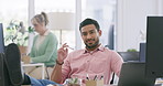 Businessman winking and flirting at a colleague in the office. Asian professional sitting with his feet up on his desk and looking contemplative. Sexual harassment in the workplace by male coworkers