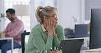 Stressed mature businesswoman feeling tired and bored while typing an email on her laptop in the office. Professional woman feeling overwhelmed while using technology. Exhausted and wanting to quit