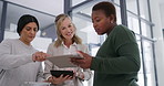 Diverse businesswomen using tablets while having a discussion in an office building. Mature ladies analyzing a business strategy as a team. Professional females having a chat while using social media