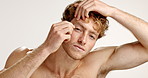 Tweezer, self care and face of man in studio for plucking eyebrows, grooming or cosmetic in morning. Shirtless, tool and portrait of male person with tweezing facial hair by white background.