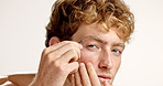 Tweezer, grooming and face of man in studio for plucking eyebrows, health or self care in morning. Wellness, cosmetic tool and portrait of male person with tweezing facial hair by white background.