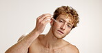 Serum, skincare and face of man in studio for vitamin c, beauty and facial treatment. Essential oil, cosmetics and self care with person and dropper on white background for dermatology and glow