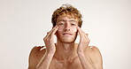 Skincare, cream and face of man in studio for hydration, self care and facial treatment. Dermatology, collagen production and glow with person and lotion on white background for shine and grooming 