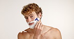 Face, razor or man shaving cream in studio for grooming routine, facial care or hair removal. Foam, white background or male person with space for dermatology mockup, skincare or cleaning hygiene