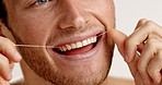 Dental health, floss and mouth of man in studio for plaque removal, fresh breath or grooming. Oral care, happy and person with string for clean teeth, cavity prevention or hygiene by white background