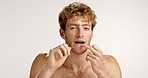 Dental floss, face or man in studio for germs, cleaning bacteria and oral hygiene on white background. Person, dentistry space and model with string for tooth to prevent cavity, decay or gum disease