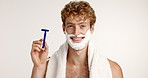 Face, razor and smile with man on studio background for grooming, hair removal or hygiene routine. Foam, shaving and skincare with satisfied person getting ready in bathroom for morning wellness