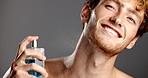Happy, cologne and man in studio, cosmetics and dermatology treatment on gray background. Smile, person and model with grooming, perfume and beauty product with fragrance bottle, aroma and wellness