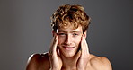 Face, skincare and man in studio for beauty, shine and glow on gray background. Portrait, smile and touch with model for hydration, collagen treatment and wellness with cosmetics for dermatology