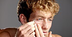 Studio, grooming and man with tweezers for eyebrow, hair removal and facial treatment for self care. Gray background, routine and person with tool for trimming, wellness and confident with equipment