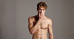 Face, skincare and body with man in studio for beauty, glow or muscle on gray background. Portrait, confident and touch with shirtless model for hydration, collagen treatment or dermatology cosmetics