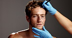 Man, face and drawing for plastic surgery in studio with lines, aesthetic or transformation by background. Person, cosmetic surgeon and pen for skin, portrait or gloves with mockup space in Argentina