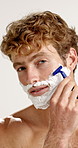 Shaver, foam and face of man in studio with grooming, epilation or self care for morning routine. Razor, health and portrait of person with shaving for hair removal treatment by white background.