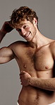Bicep, face and smile of shirtless man in studio for masculine grooming, hygiene or skincare. Body, fitness and wellness with happy muscular model on gray background for health or transformation