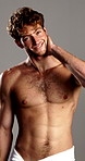 Smile, skincare and man with towel in studio for wellness, cleaning and hygiene routine. Dermatology, beauty and portrait of person with confidence for cosmetics, washing or shower on gray background