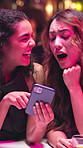 Happy women, friends and laughing with phone in nightclub for funny joke, post or social media. Female people, customer or user with smile on mobile smartphone for late evening or night out in bar