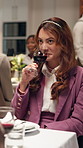 Woman, date and drink red wine at restaurant for relax, romantic dinner and thinking. Person, alcohol glass and tasting beverage in diner at event, social gathering and reflection for happy hour