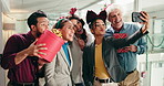Christmas, selfie and group of business people laugh at festive celebration with gifts. Xmas, team and photo of friends in office for holiday spirit, peace sign or wave for social media post at party