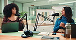 Content creation, women and host with mic for interview, creative and live streaming podcast on web. Happy, people and laughing with guest in studio, conversation and podcaster with laptop for audio