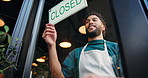 Man, waiter and closed sign with door in cafe for no service, message or end of business. Male person, barista or employee closing restaurant with billboard or signage on window for closure or notice