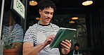 Waiter, door and typing on tablet in restaurant for seating plan, welcome and order management. Barista, small business and man with digital app at cafe entrance for hospitality and customer service