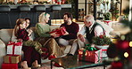 Happy family, box or christmas with gift on sofa for surprise or celebration together in home. Grandparents, parents and child with wrapped present for december holiday, giving or christian tradition