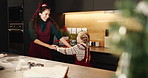 Mom, girl and dancing in kitchen at Christmas, celebration and happy with cooking in family home. People, mother and daughter with holding hands, laugh and excited for xmas with bonding in house