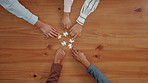 Puzzle, problem solving and hands of business people in office for corporate solution with partnership. Jigsaw, team building and top view of employees with collaboration, synergy or link on table. 