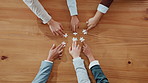 Above, hands and business people with puzzle for teamwork, cooperation or problem solving. Top view, group and jigsaw piece for collaboration, connection and solution with synergy on table with space