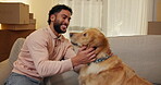 Happy, man and playing with dog in new home for property purchase, mortgage success or security. Homeowner, person or excited with animal on sofa for pet friendly apartment, relocation or achievement