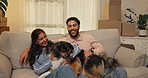Happy, couple and playing with dog in new home for security, mortgage purchase and achievement. Moving in, people and excited with animal on sofa for property investment, goals and bonding together