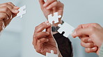 Puzzle, hands and business people in office for solution, problem solving or cooperation. Jigsaw, teamwork and group of corporate employees with collaboration, planning or synergy in workplace.