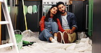 Couple, tired and hug with painting for kitchen renovations, upgrade and maintenance. New home, man and woman resting for diy, makeover and decoration decision with creative homeowner and art tools