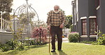 Outdoor, walking stick and old man with retirement, wellness and weekend break with nature. Backyard, pensioner and elderly person with disability, cane and peace with mobility support for arthritis