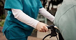 Hands, nurse and push patient with wheelchair at retirement village, outdoor and support for mobility. People, caregiver and job with elderly person with disability, help and senior services on walk
