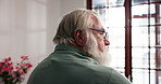 Alone, depression and regret with senior man in retirement home for memories or nostalgia. Anxiety, relax and thinking with unhappy old person in bedroom of apartment for contemplation or frustration