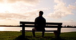Lake, thinking or man on park bench at sunset on holiday vacation in countryside or nature, Travel, chill or back view of calm person with outdoor peace for fresh air, wellness and break to relax
