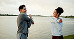 Fitness, talking and couple with stretching at lake for warm up training, getting ready or support. Teamwork, people and arm workout in nature for muscle flexibility, running exercise or conversation