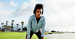 Tired, fitness and woman breathe with headphones in park for running, marathon training and exercise. Sports, outdoor and person with music for fatigue, rest and break for workout, challenge or race