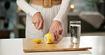 Kitchen, water and woman cut lemon in home for vitamin c, hydration and digestion benefits. Morning, counter and person with citrus fruit for gut health, wellness and minerals for antioxidant detox