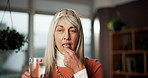 Home, healthcare and woman with pills, water and drinking medicine for wellness, treatment or drugs. Happy, senior person and healthy with vitamins in house, prescription and supplements in morning