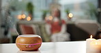Peace, candle and relax with diffuser in home for aromatherapy, calm and stress relief. Humidifier, self care and zen with person in living room of apartment for aroma, essential oils and holistic