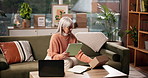 Tablet, mature woman and box for ecommerce, logistics and check label for order with remote work. Package, technology and serious freelance entrepreneur in home for stock, shipping or problem solving