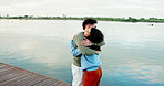Couple, hug and happy by lake with walk, reunion and holding hands on date, love and holiday. Gen z people, man and woman with embrace, hello greeting or smile in discussion on vacation in Colombia