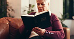 Bible, relax and retirement with senior woman on sofa in living room of home to study religion. Belief, faith and reading book with Christian person learning gospel in apartment for spirituality