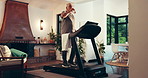 Drinking, treadmill and walking with senior man in living room of home for health or hydration. Physiotherapy, rehabilitation and water with old person in apartment for cardio exercise or fitness