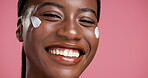 Face, black woman and sunscreen for skincare in studio for beauty, facial hydration and shine. Smile, female person and spf with moisturising benefits, treatment glow and self care on pink background