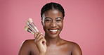 Makeup, face and black woman with brushes, facial and grooming in studio on pink background. Female person, aesthetic and happy model with cosmetic tools, shine and natural beauty with skincare