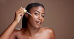 Face, skincare and woman with serum, smooth or cosmetic for anti aging, benefits or hyaluronic acid. Happy, black person and facial treatment with oil for glow, studio background and liquid for skin